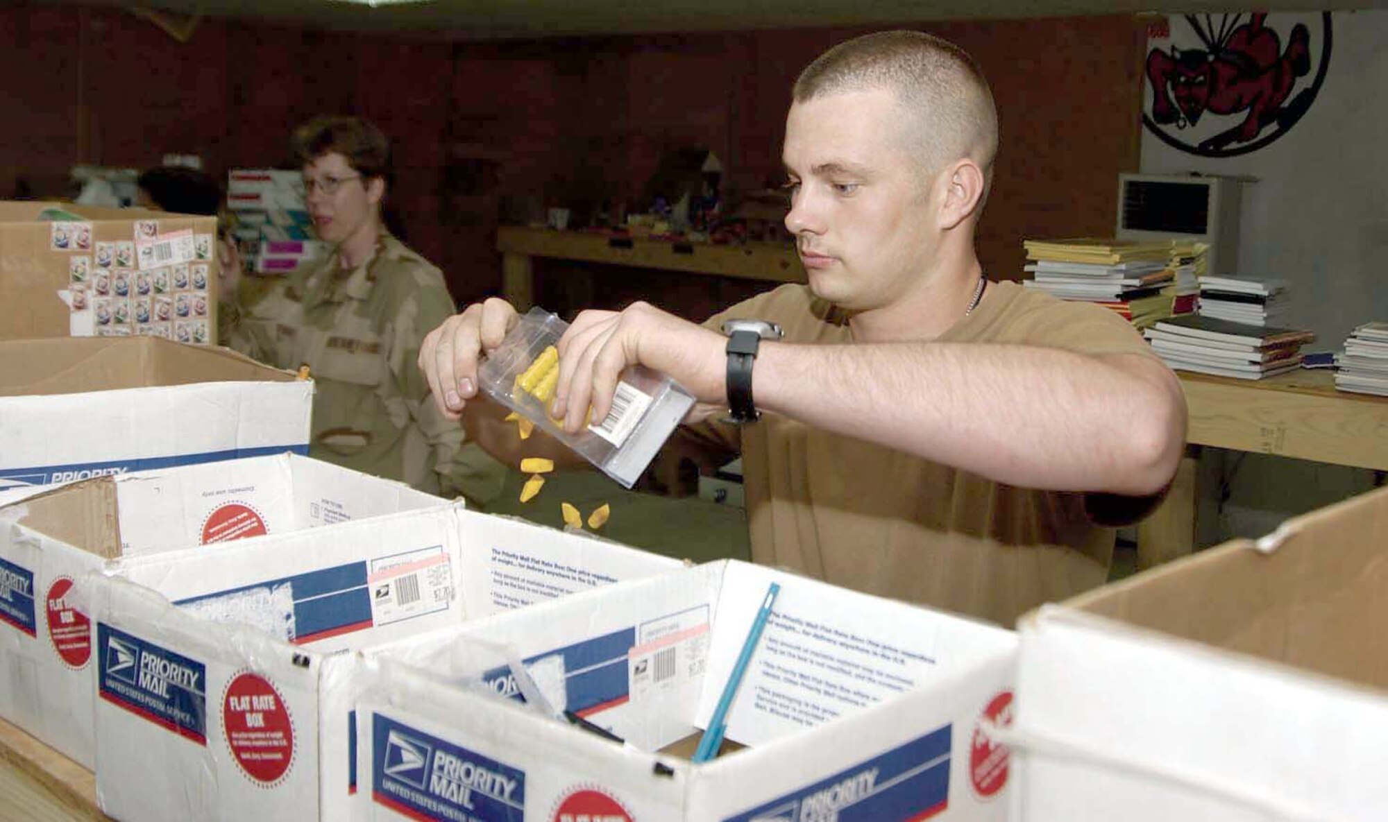 KIRKUK AIR BASE, Iraq -- Airman 1st Class Riley Williams opens packages of items that will be sorted into individual bags for local schools.  He is assigned to the 506th Expeditionary Logistics Readiness Squadron.  (U.S. Air Force photo by Tech. Sgt. Christopher Gish)