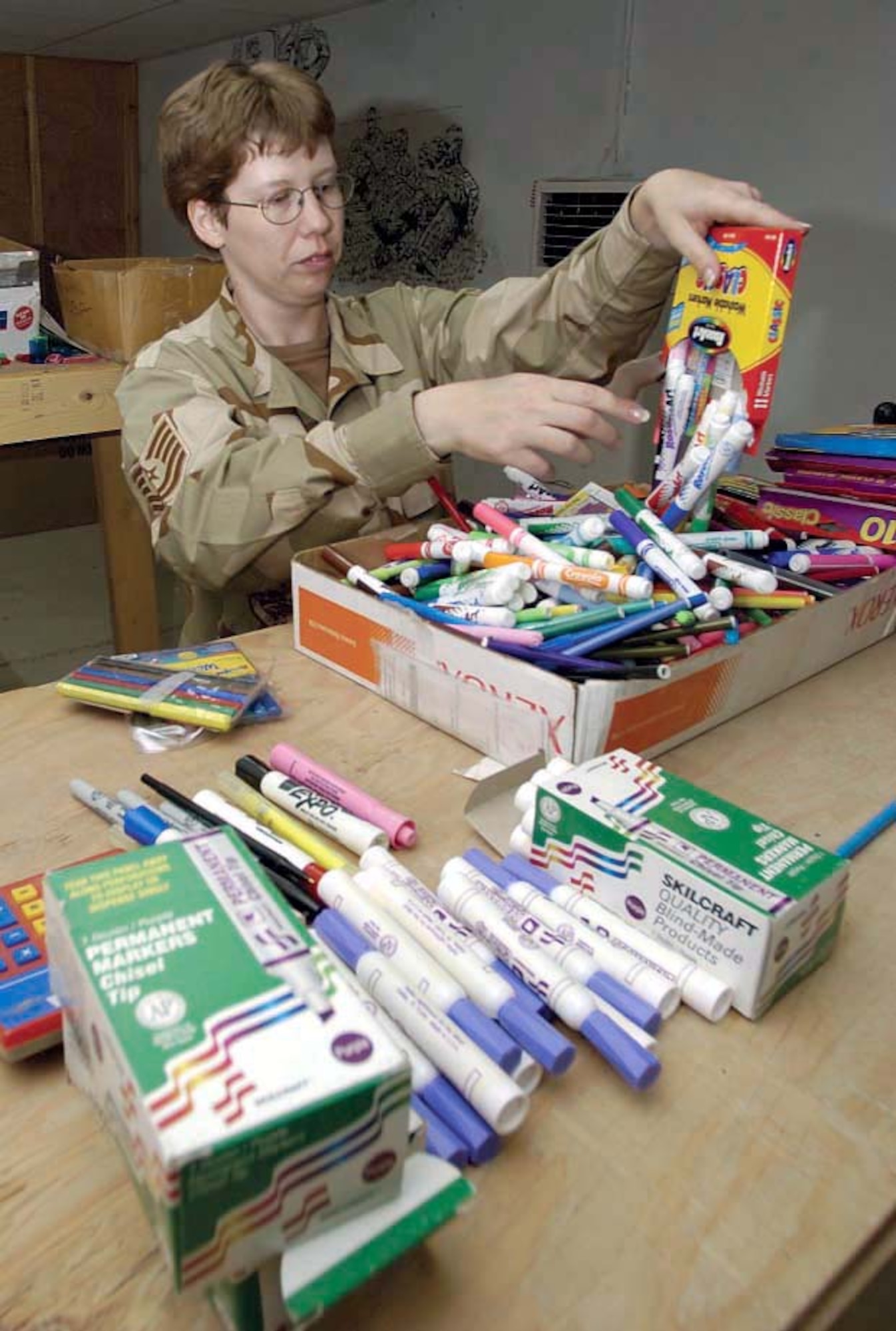 KIRKUK AIR BASE, Iraq -- Tech Sgt. Loretta Grantman empties boxes of markers so they may be sorted into bags for local Iraqi schoolchildren.  She is assigned to the 506th Air Expeditionary Group's legal office.  (U.S. Air Force photo by Tech. Sgt. Christopher Gish)