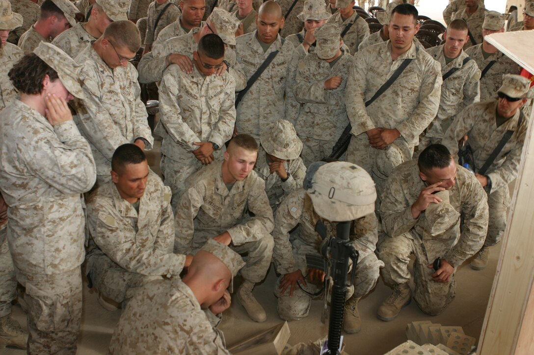 AL ASAD, Iraq (June 14, 2005) - Fellow Marines with 4th Squad, Military Police Detachment, and friends gather around to pay their last respects to Lance Cpl. Marc L. Tucker, a motor transportation operator augmented as a military policeman, MP Detachment, Combat Logistics Battalion 2, 2d Force Service Support Group (Forward).  Tucker, a Pontotoc, Miss., native, was attached to 4th Squad, MP Detachment, and deployed to Iraq to provide security for the explosive ordnance disposal team, recovery missions, engineer crater repair missions and convoys. He lost his life while supporting Operation Iraqi Freedom 04-06. During the memorial service, Tucker's friends talked about how he influenced and touched each one of their lives. They talked about the funny memories and what they are going to miss.  Most of the Marines spoke of the great amount of respect and love they have for their "brother."