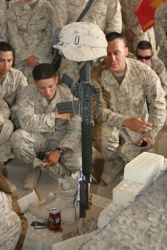 AL ASAD, Iraq (June 14, 2005) - Fellow Marines with 4th Squad, Military Police Detachment, and friends gather around to pay their last respects to Lance Cpl. Marc L. Tucker, a motor transportation operator augmented as a military policeman, MP Detachment, Combat Logistics Battalion 2, 2d Force Service Support Group (Forward).  Tucker, a Pontotoc, Miss., native, was attached to 4th Squad, MP Detachment, and deployed to Iraq to provide security for the explosive ordnance disposal team, recovery missions, engineer crater repair missions and convoys. He lost his life while supporting Operation Iraqi Freedom 04-06. During the memorial service, Tucker's friends talked about how he influenced and touched each one of their lives. They talked about the funny memories and what they are going to miss.  Most of the Marines spoke of the great amount of respect and love they have for their "brother."