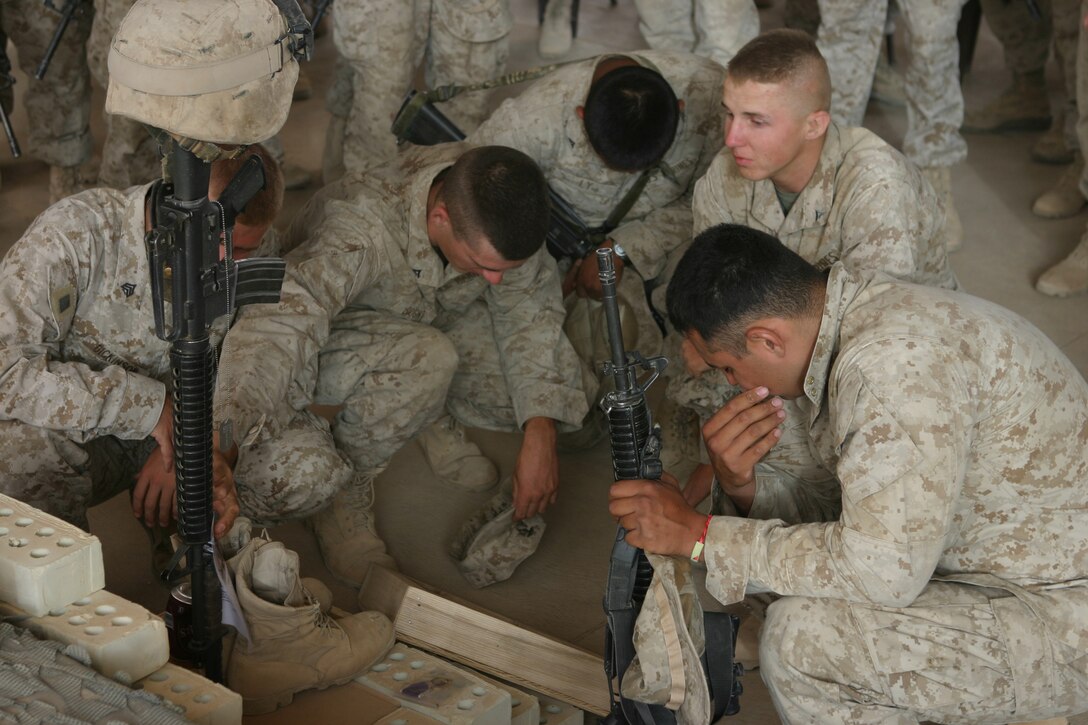 AL ASAD, Iraq (June 14, 2005) - Fellow Marines with 4th Squad, Military Police Detachment, and friends gather around to pay their last respects to Lance Cpl. Marc L. Tucker, a motor transportation operator augmented as a military policeman, MP Detachment, Combat Logistics Battalion 2, 2d Force Service Support Group (Forward).  Tucker, a Pontotoc, Miss., native, was attached to 4th Squad, MP Detachment, and deployed to Iraq to provide security for the explosive ordnance disposal team, recovery missions, engineer crater repair missions and convoys. He lost his life while supporting Operation Iraqi Freedom 04-06. During the memorial service, Tucker's friends talked about how he influenced and touched each one of their lives. They talked about the funny memories and what they are going to miss.  Most of the Marines spoke of the great amount of respect and love they have for their "brother."