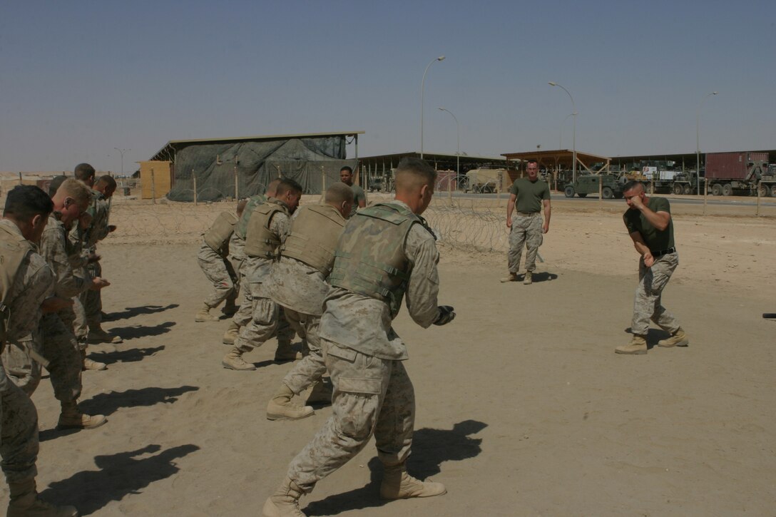 AL ASAD, Iraq (June 23, 2005) - Staff Sgt. Paul Denning, company gunnery sergeant for Transportation Support Company, Combat Logistics Battalion 2, 2d Force Service Support Group (Forward) - otherwise known as "Team Carnivore"- and the Marines in the grey belt martial arts course practice martial art moves.  Denning, a Whitehouse Station, N.J., native, is a black belt instructor in the Marine Corps Martial Arts Program, and wants to train as many of the more than 200 Marines in his company up at least one martial arts belt higher than they are now