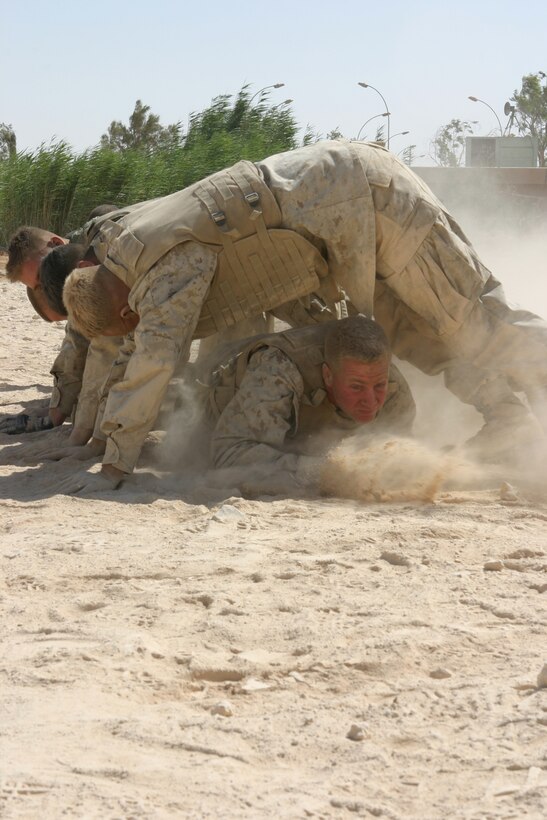 AL ASAD, Iraq (June 23, 2005) - The Marines "build-a-house" during the combat fitness portion of the grey belt martial arts course they are in. Staff Sgt. Paul Denning, a Whitehouse Station, N.J., native, and company gunnery sergeant for Transportation Support Company, Combat Logistics Battalion 2, 2d Force Service Support Group (Forward) - otherwise known as "Team Carnivore"- wants to train as many of the more than 200 Marines in his company up at least one martial arts belt higher than they are now.