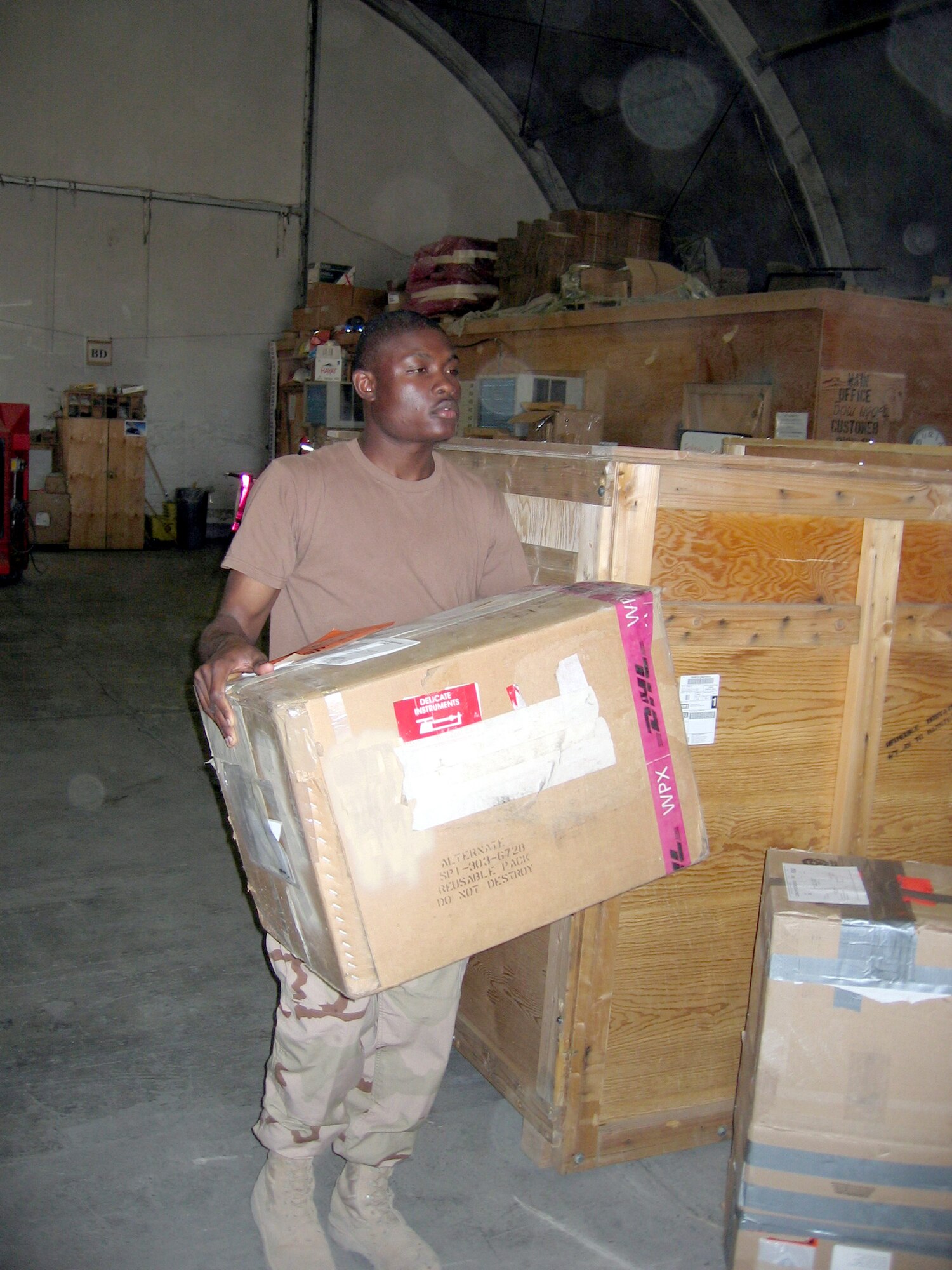 KARSHI-KHANABAD AIR BASE, Uzbekistan -- Airman Guesley Leger carries an inbound shipment to its destination in the supply shop here.  He is a supply apprentice with the 416th Expeditionary Mission Support Squadron's supply section and is deployed from Royal Air Force Mildenhall, England.  (U.S. Air Force photo by Staff Sgt. Shad Eidson)