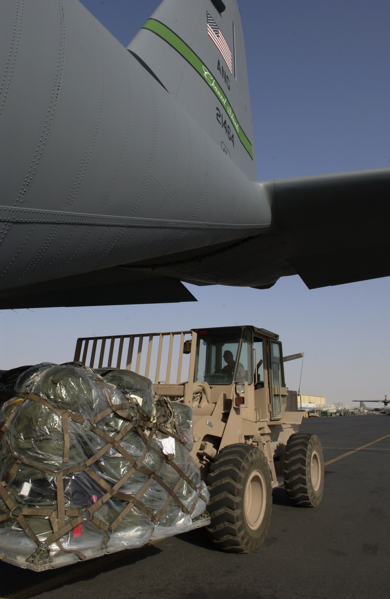 SOUTHWEST ASIA -- An aerial port Airman removes cargo from a stretch version C-130J Hercules at a forward-deployed location here June 7.  The plane is from the California Air National Guard's 146th Airlift Squadron and is supporting missions in Iraq, Afghanistan and the Horn of Africa.  The J-model is the latest upgrade to the C-130 cargo plane series.  (U.S. Air Force photo by Tech. Sgt. Randy Mallard)