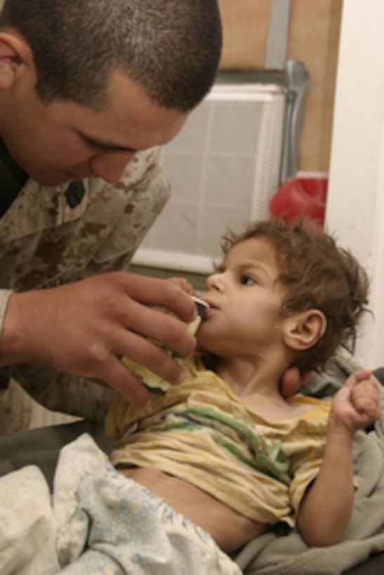 A U.S. Navy Hospital Corpsman treats one of two Iraqi children brought into the Regimental Combat Team 2 Aide Station at Camp Ripper, Al Asad, Iraq, on June 8, 2005. The children were found tied to a cinder block during a house raid in Dhulab, Iraq, by Marines attached to 2nd Marine Division as they conducted counter-insurgency operations with Iraqi Security Forces. 