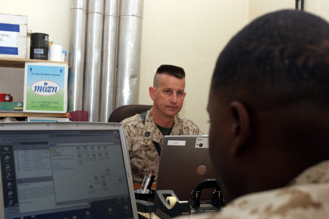 AL ASAD, Iraq ? Gunnery Sgt. Steven Teague, administration chief with Marine Fighter Attack Squadron 142 listens as Cpl. Marques Bates, administration clerk with the VMFA-142 asks a question regarding a Marines administration problem.