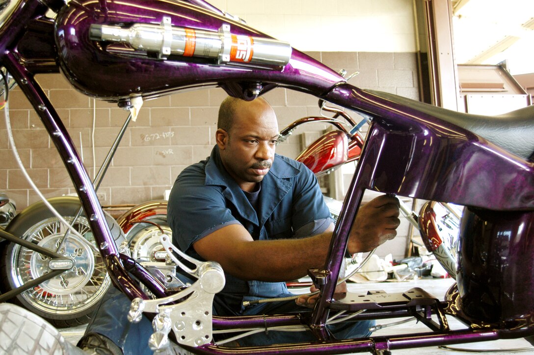 HICKAM AIR FORCE BASE, Hawaii -- Tech. Sgt. Greg Price attaches an oil line to a pro street chopper he is building to show in the 3rd Annual Choppers-Only Show in Honolulu.  This is the 14th bike he has built in the past four years.  He is a C-40B aircraft crew chief with the 15th Airlift Maintenance Squadron here.  (U.S. Air Force photo by Tech. Sgt. Martin Jackson)