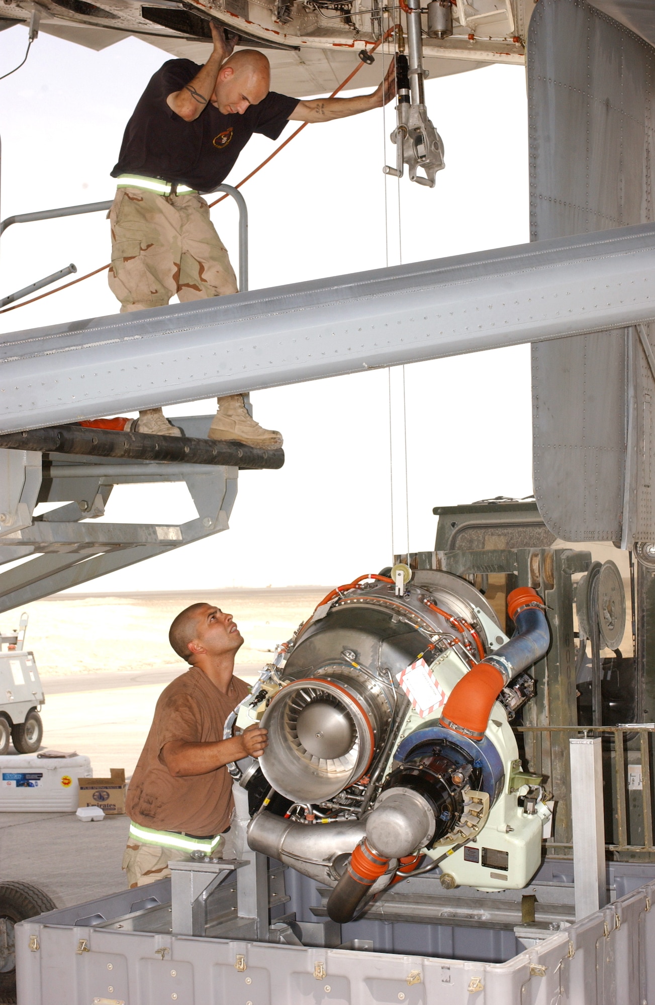 SOUTHWEST ASIA -- Staff Sgt. Erik Barnhart (on the stand) and Airman 1st Class Jose Cabiya change an auxiliary power unit on a KC-10 Extender.  The 10th Aircraft Maintenance Unit's Airmen helped get the refueler airborne allowing fighter aircraft needing fuel to continue to provide cover for Soldiers on the ground in Iraq on June 7.  (U.S. Air Force photo by Senior Airman Elijah Roberts)