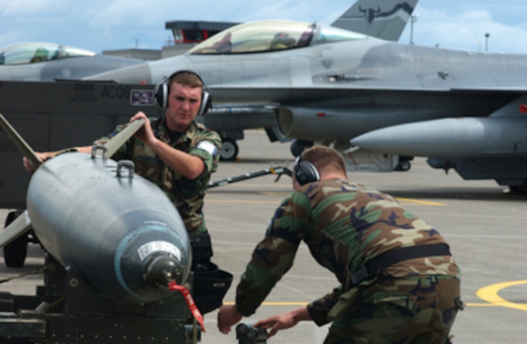 Two airmen from the 120th Logistics Group ready a bomb for loading on an F-16C Fighting Falcon at Great Falls, Mont., on June 8, 2005. The Falcon, of the 186th Fighter Squadron, Montana Air National Guard, is being readied for a mission during Big Sky 05-02, an operational readiness exercise held at Great Falls. 