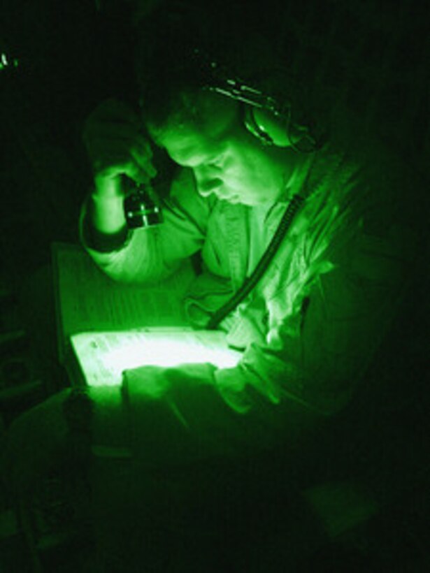 U.S. Air Force Staff Sgt. John Brockman reviews airdrop technical orders by flashlight while en route to Kandahar Air Base, Afghanistan, to pickup humanitarian relief pallets containing medical supplies, food and blankets, on June 10, 2005. The pallets will be airdropped by a C-130E Hercules to U.S. Army soldiers in rural areas of Afghanistan who will then distribute them to villagers in the local area. Brockman is a C-130E Hercules loadmaster deployed from Pope Air Force Base, S.C., and is assigned to the 737th Expeditionary Airlift Squadron in support of Operation Enduring Freedom. 