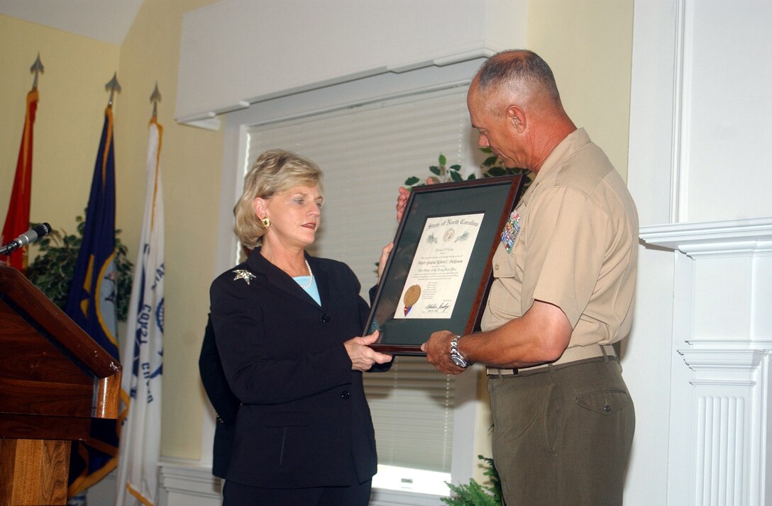 MARINE CORPS BASE CAMP LEJEUNE, N.C. - Lieutenant Gov. Beverly Purdue presents Maj. Gen. Robert C. Dickerson, commanding general, Marine Corps Base, with the Long Leaf Pine award for his history of service to the community at the Paradise Point Officer's Club June 13.   The Long Leaf Pine award is presented to an individual for dedication and extended length to an organization as the State of North Carolina's highest honor. Purdue presented the award on behalf of North Carolina Gov. Mike Easley.  (Official Marine Corps photo by Pfc. Drew Barker)