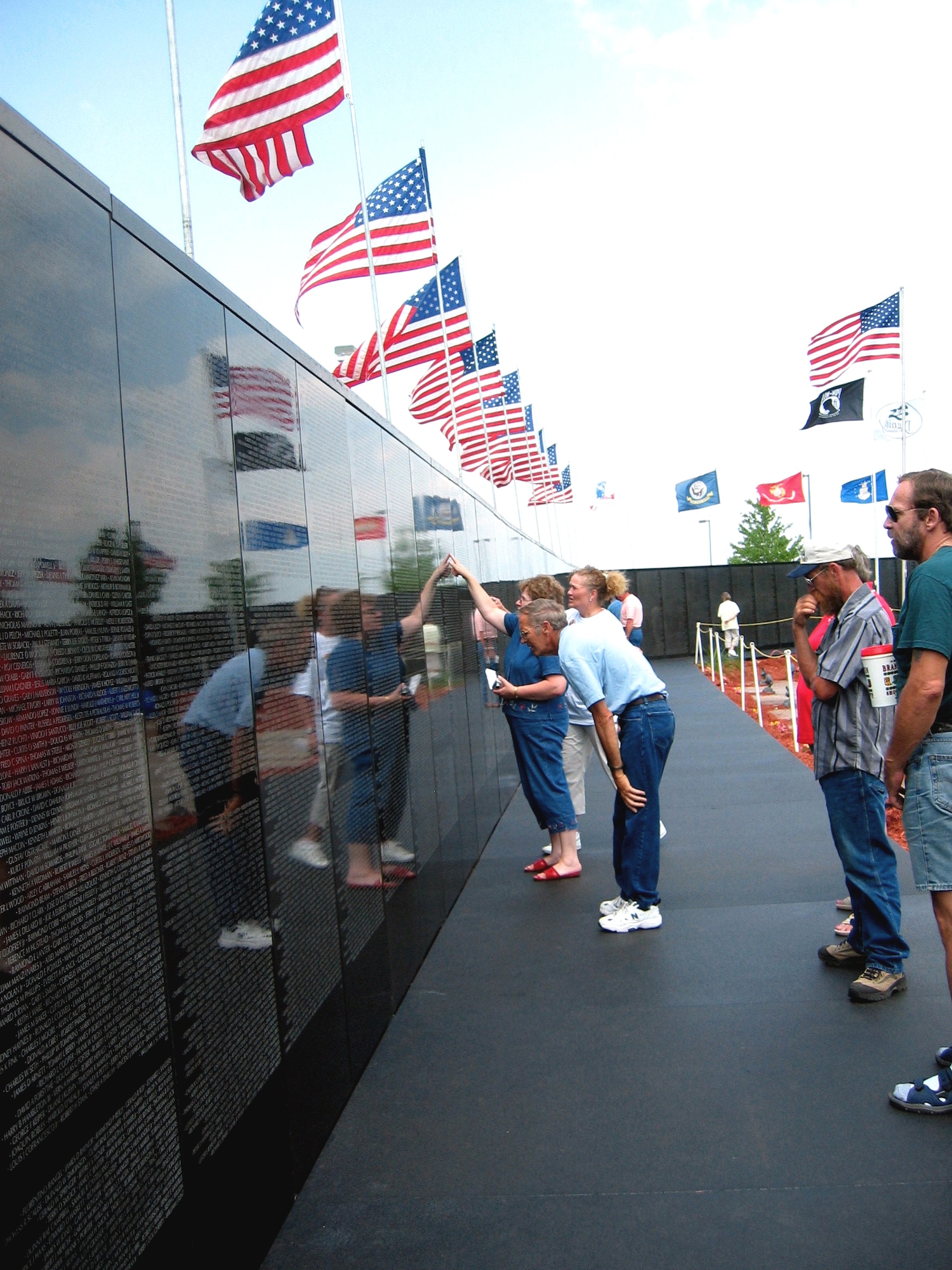 BRANSON, Mo. -- Vietnam veterans check for familiar names at the "Dignity Memorial Vietnam Wall," the largest of several "traveling" replicas of the Vietnam Veterans Memorial in Washington.  The wall is on display during Operation Homecoming USA here through June 18.  (Department of Defense photo by Donna Miles)