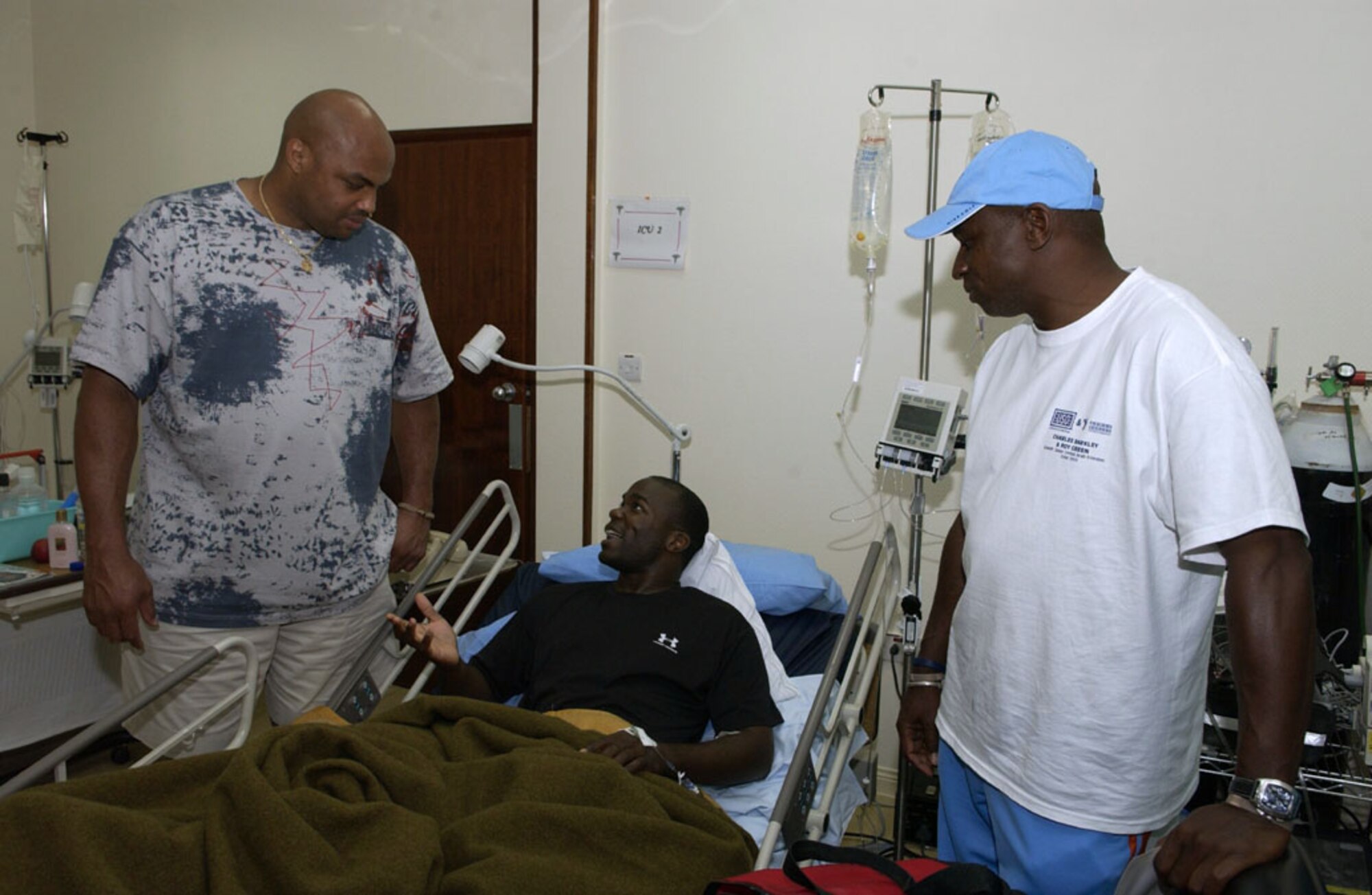 SOUTHWEST ASIA -- Staff Sgt. Kevin Campbell tries to explain to Charles Barkley (left) that being a teammate of the Philadelphia 76ers does not qualify him to render medical advice during a United Services Organization Tour visit June 13.  Roy Green, 14-year National Football League wide receiver on the tour with Mr. Barkley, agreed.  Sergeant Campbell is assigned to the 379th Expeditionary Aircraft Maintenance Squadron at a forward-deployed location and is from Grand Forks Air Force Base, N.D.  (U.S. Air Force photo by Tech. Sgt. Randy Mallard)