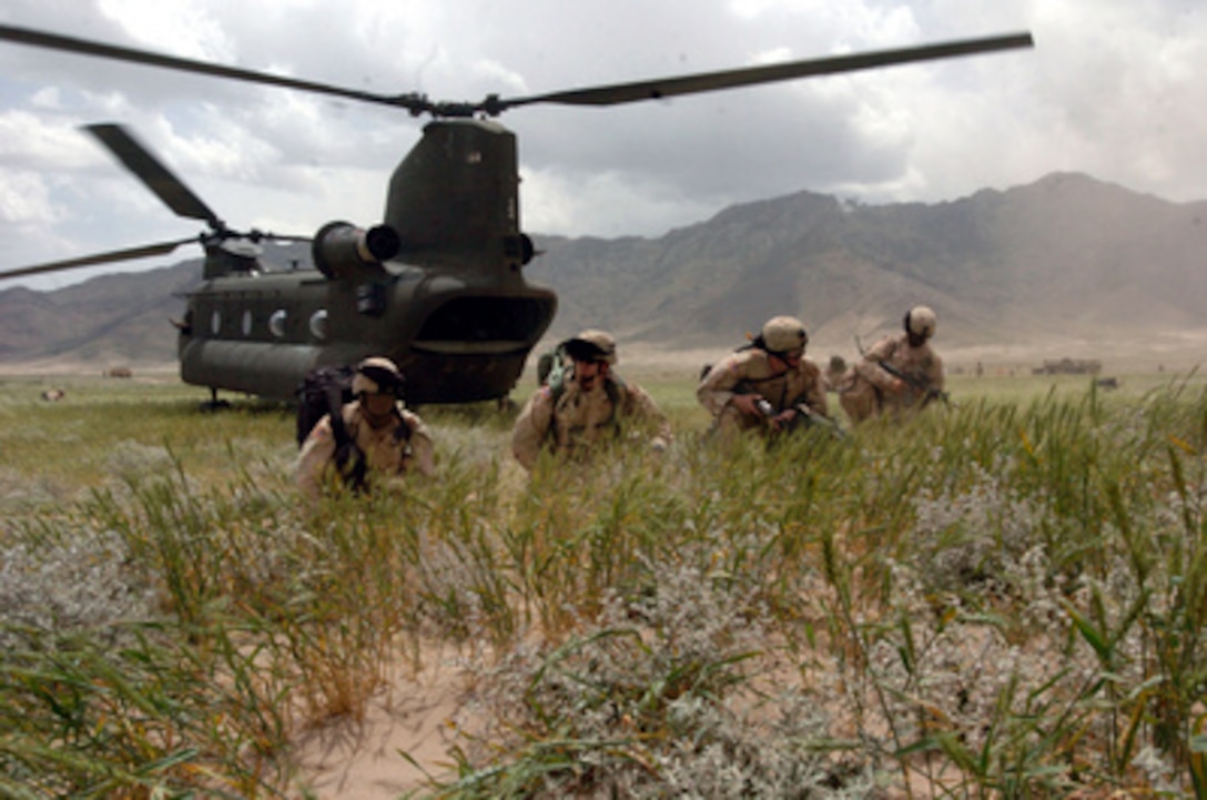Soldiers establish a security perimeter after exiting a U.S. Army CH-47 Chinook helicopter during a Quick Reaction Force exercise at the East River Range near Bagram, Afghanistan, on June 10, 2005. The soldiers are from Alpha Company, 3rd Battalion, 141st Infantry Regiment of the Texas Army National Guard. 