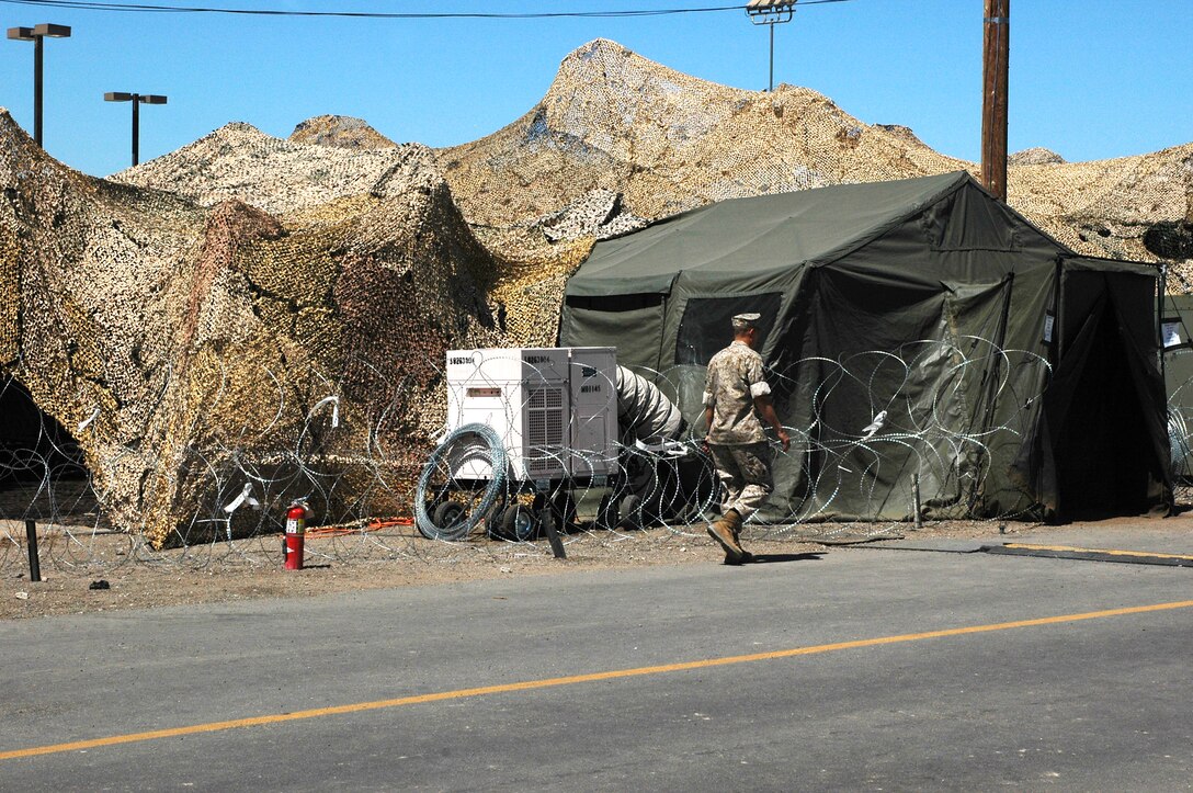 A Marine heads to the entrance of the Tactical Air Command Center. The TACC is where the decisions for the air war are made.  The decisions cover all the six functions of Marine Corps aviation, including air defense, offensive air support, air reconnaissance, electronic warfare, assault support and control of aircraft and missiles are all directed by the TACC.
