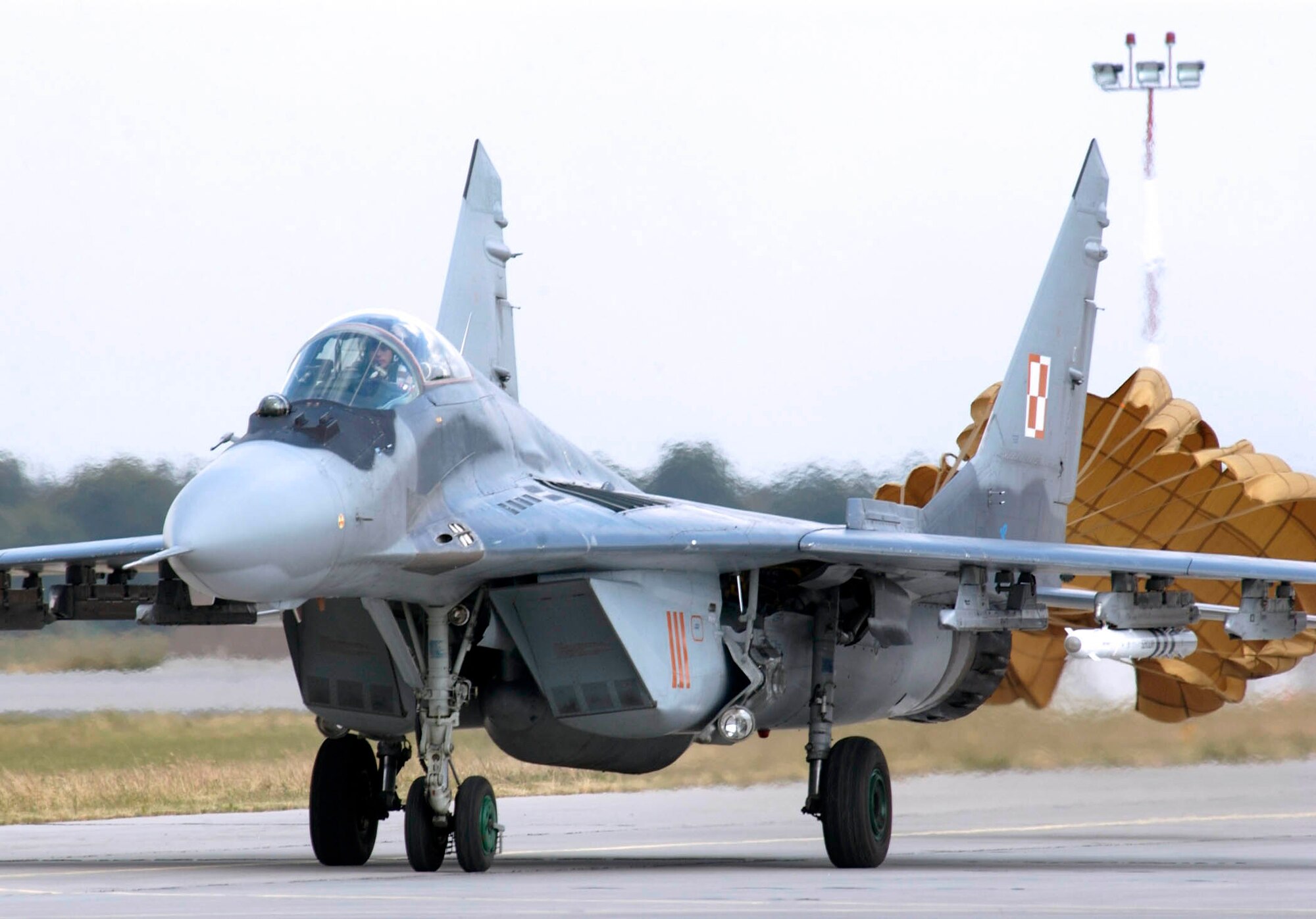 POZNAN, Poland -- A Polish air force MiG-29 taxis in with parachute in tow after finishing a mission here.  Airmen from the Illinois Air National Guard's 183rd Fighter Wing are familiarizing Polish airmen with the F-16 Fighting Falcon during the U.S. European Command exercise Sentry White Falcon 2005 through June 17.  In 2006, the Polish air force will start receiving their own F-16s that will begin replacing their Soviet-made MiG fighters as the country modernizes its military to NATO standards.  (U.S. Air Force photo by Master Sgt. John E. Lasky)