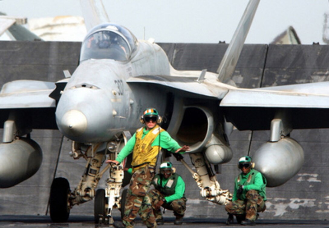 A catapult safety observer looks to ensure that all personnel are clear of the foul lines before attaching the nose gear of an F/A-18C Hornet to the catapult shuttle prior to launching from the USS Carl Vinson (CVN 70) on June 13, 2005. The Carl Vinson Carrier Strike Group is conducting operations in support of multi-national forces in Iraq and maritime security operations in the Persian Gulf. Vinson will end its deployment with a homeport shift to Norfolk, Va., to commence a three-year refuel and complex overhaul. The Hornet is assigned to Strike Fighter Squadron 146, which is deployed aboard the Vinson from Naval Air Station Lemoore, Calif. 