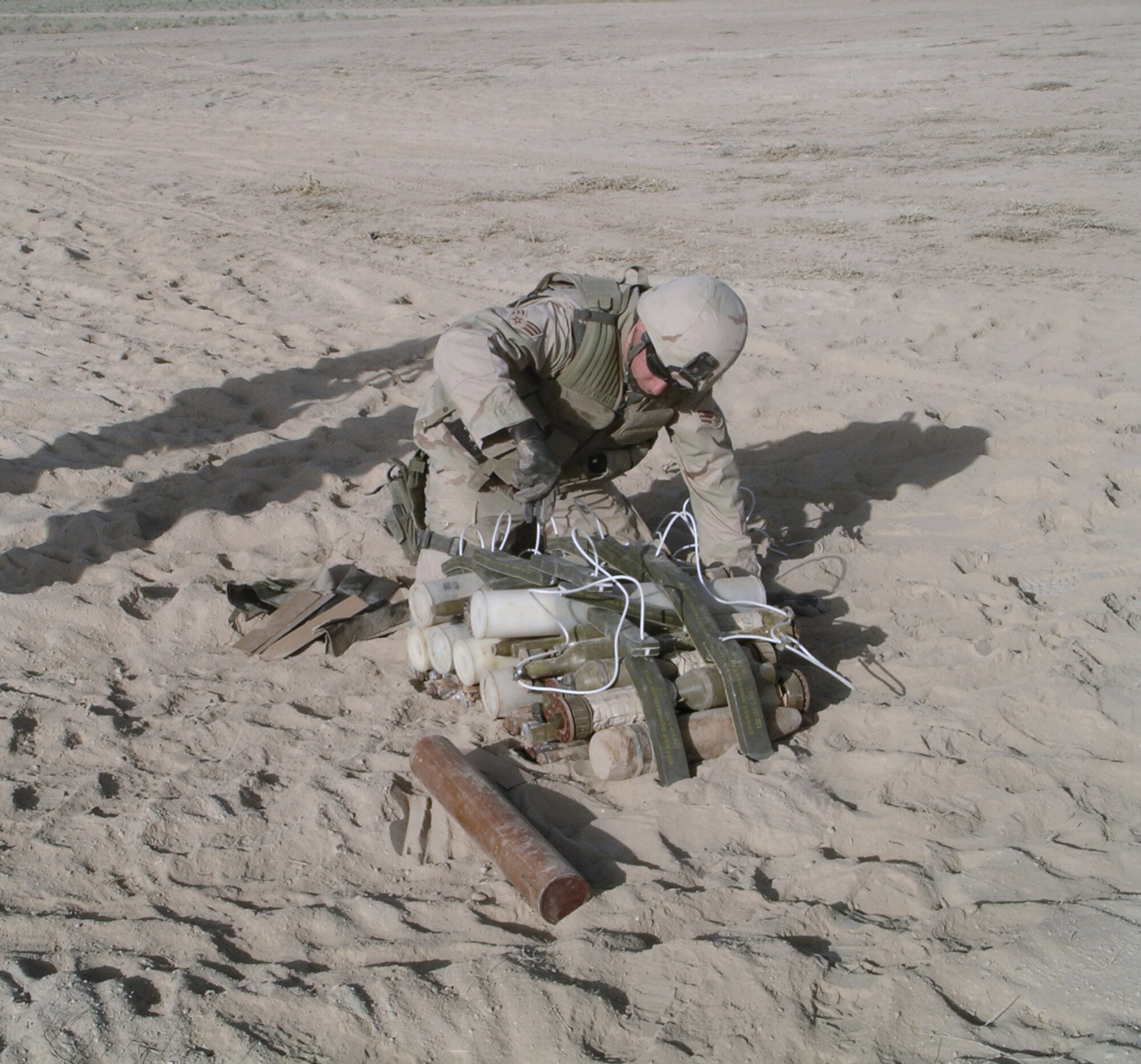 KANDAHAR AIRFIELD, Afghanistan -- Senior Airman Eric Benbrooks places C-4 explosives on a pile of recovered munitions found in the area in preparation for a controlled detonation.  He is assigned to the 451st Air Expeditionary Group's explosive ordnance disposal flight and is deployed from Hickam Air Force Base, Hawaii.  (U.S. Air Force photo by Master Sgt. Jim Skyberg)