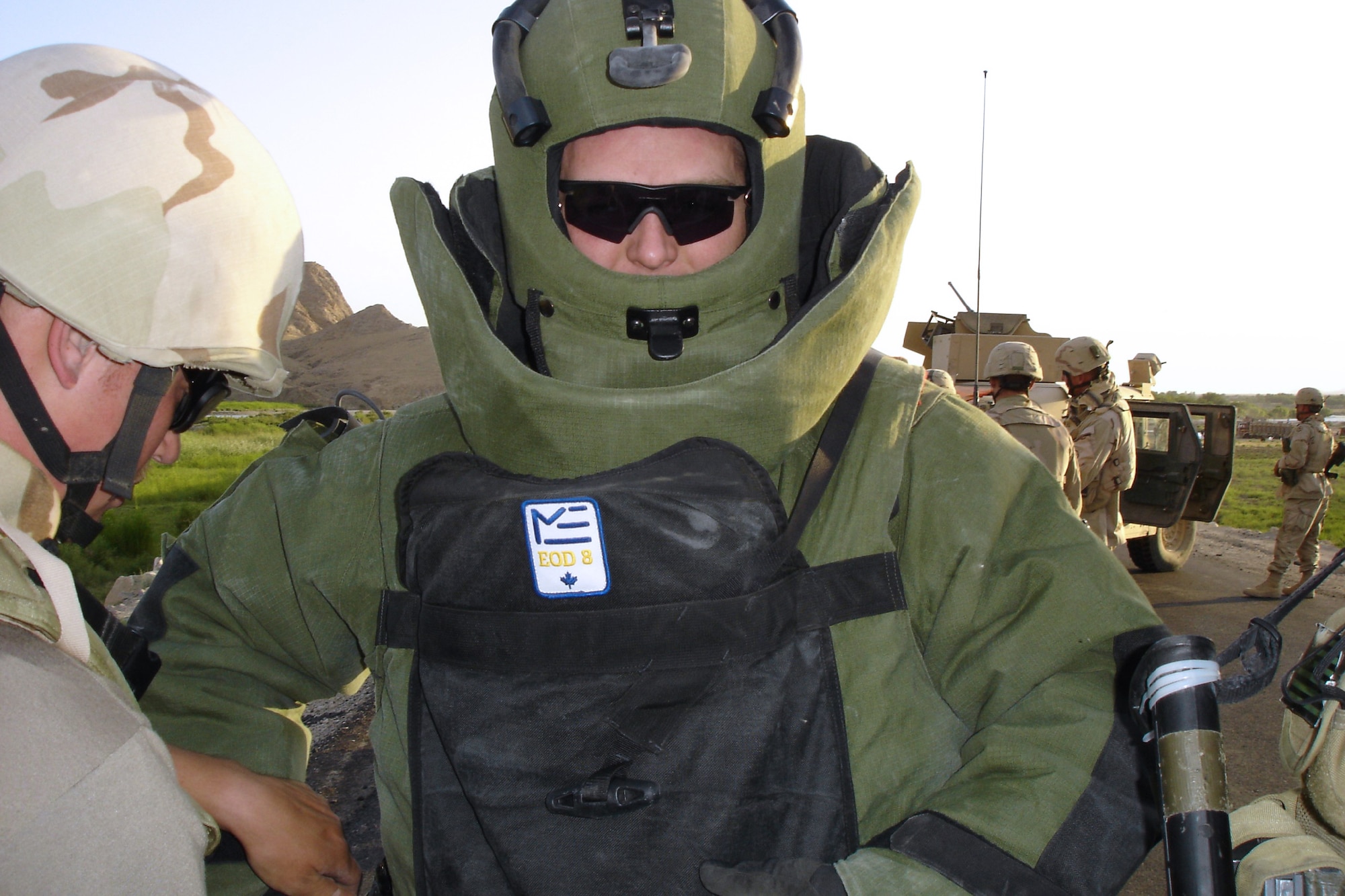 KANDAHAR AIRFIELD, Afghanistan -- Staff Sgt. Dave Baker dons a bomb suit before investigation an explosive device in southern Afghanistan.  Senior Airman Charles Hodge helps adjust the suit.  The Airmen are assigned to the 451st Air Expeditionary Group's explosive ordnance disposal flight.  Sergeant Baker is deployed from Kadena Air Base, Japan, and Airman Hodge is deployed from Luke Air Force Base, Ariz.  (U.S. Air Force photo by Master Sgt. Jim Skyberg)
