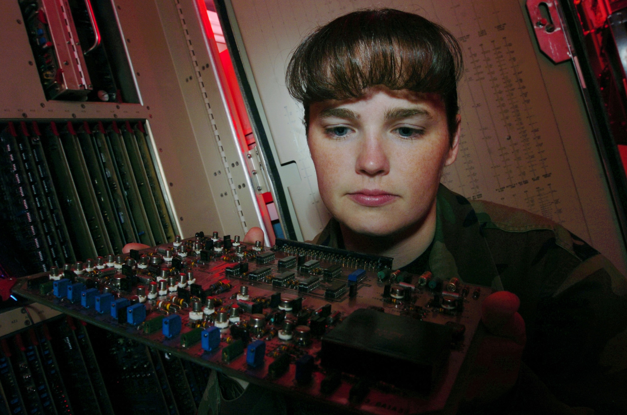 YOKOTA AIR BASE, Japan -- Staff Sgt. Kelly McKenzie inspects a circuit card for airport surveillance radar processor equipment during a preventive maintenance inspection here.  Radar technicians install, maintain, overhaul and repair ground aircraft control and warning systems used to guide incoming and outgoing aircraft here.  She is assigned to the 374th Communications Squadron.  (U.S. Air Force photo by Master Sgt. Val Gempis) 