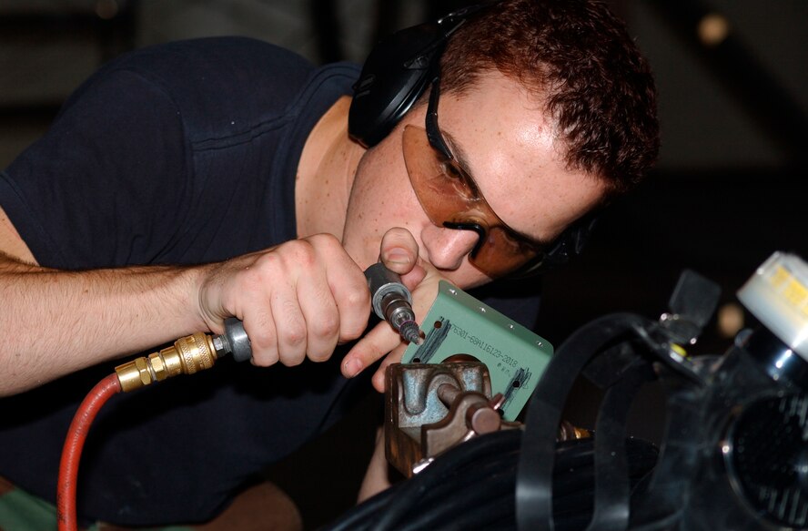 KADENA AIR BASE, Japan -- Airman 1st Class Spencer Doyle grinds a bracket before placing it on an F-15C Eagle here recently.  Airman Doyle is assigned to the 18th Equipment Maintenance Squadron.  (U.S. Air Force photo by Airman 1st Class Heather L. Tower) 