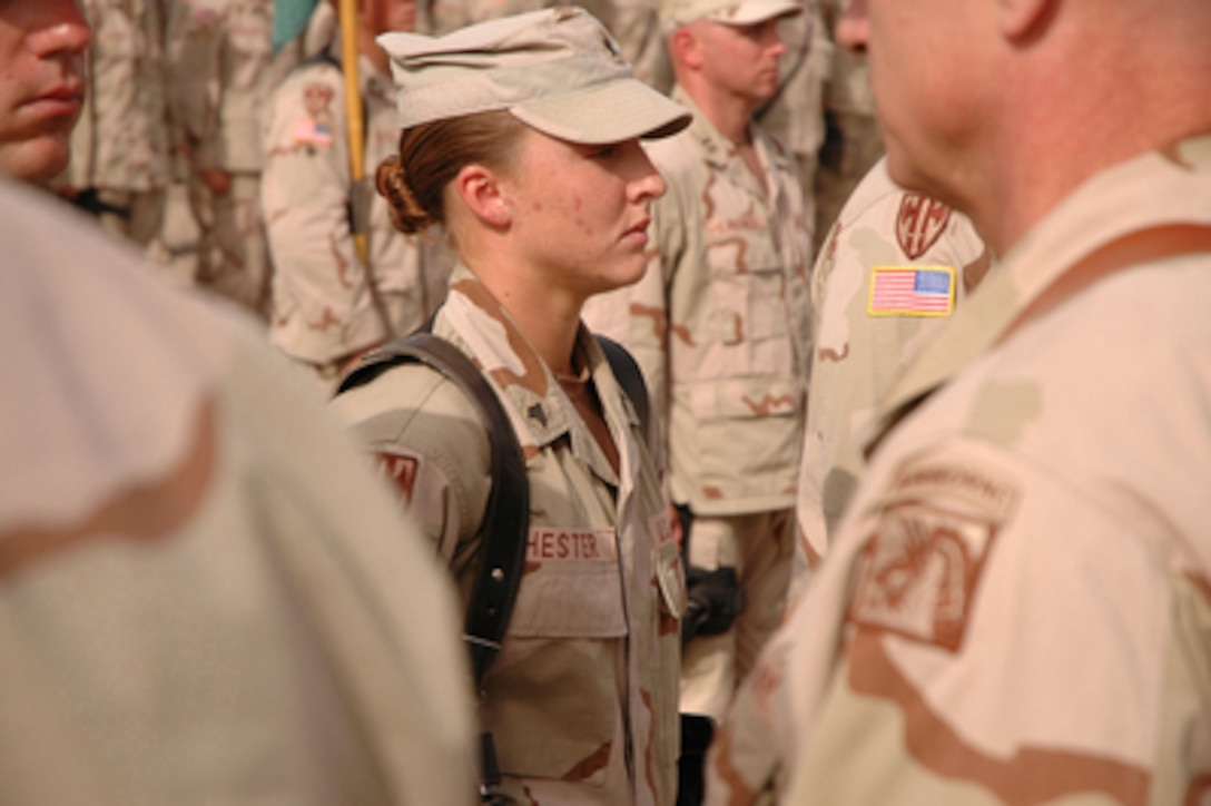 U.S. Army Sgt. Leigh Ann Hester stands at attention before receiving the Silver Star during an awards ceremony at Camp Liberty, Iraq, on June 16, 2005. Hester is assigned as a vehicle commander with the 617th Military Police Company of the Kentucky National Guard and is the first female soldier to receive the Silver Star since World War II. 