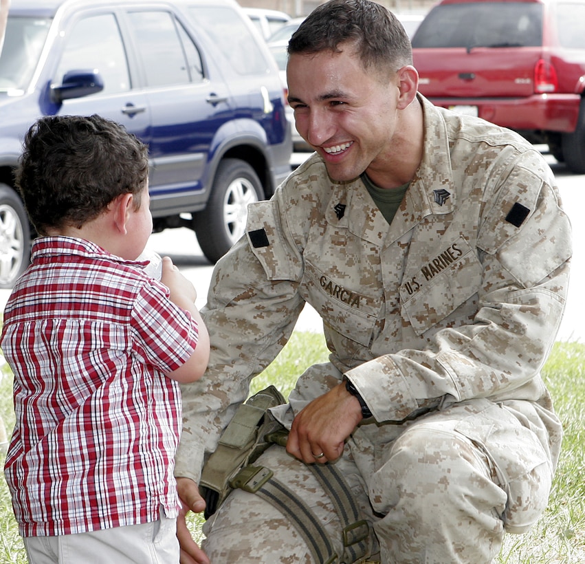Sgt. George Garcia III, Arabic linguist, 2nd Radio Battalion, II Marine Expeditionary Force, spends a happy moment with his son after arriving at Camp Lejeune from Iraq June 17. The battalion came home after serving 10 months in Iraq.