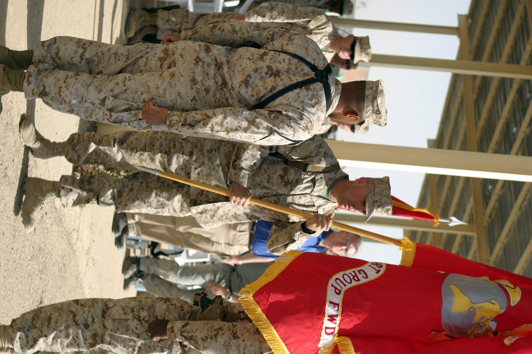 CAMP TAQADDUM, Iraq -- Brigadier Gen. John E. Wissler, a Brooklyn Park, Minn., native, passes the 2d Force Service Support Group colors back the sergeant major after receiving them from Brig. Gen. Ronald S. Coleman.  Coleman, a Darby, Pa., native, relinquished command of 2d FSSG to Wissler June 19, 2005.