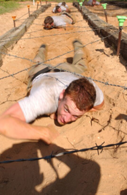 U.S. Air Force Combat Controller students do a thirty-foot low crawl under barbed wire during a confidence course at Hurlburt Field, Fla., on June 9, 2005. The students of Class 013, Advanced Skills Training, will graduate June 10th. 