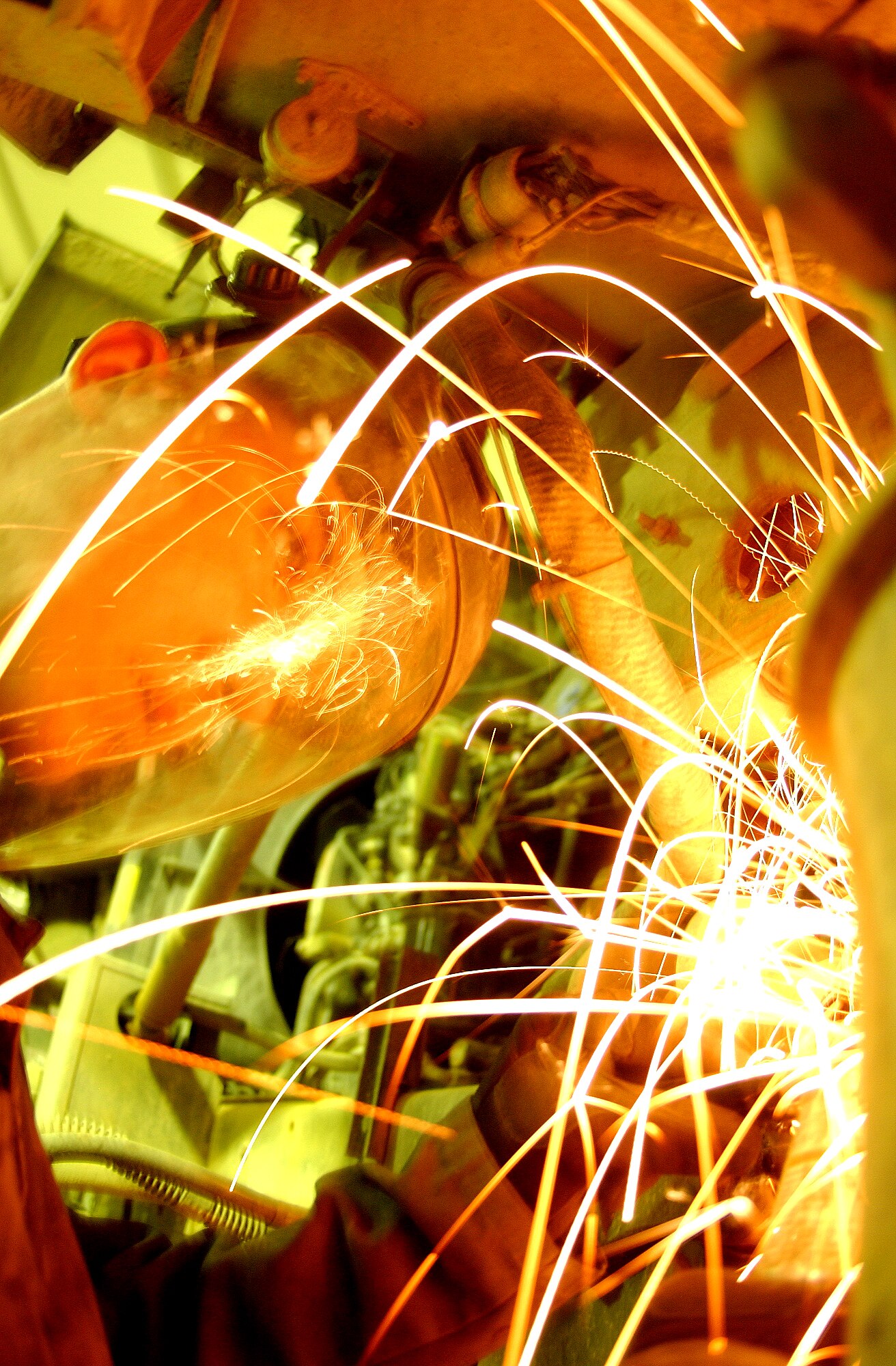 BALAD AIR BASE, Iraq -- Airman 1st Class Joshua Gates grinds down a piece of metal on a truck before Airmen of the 732nd Expeditionary Mission Support Group add armor to it.  Airman Gates is a vehicle maintainer in the group's add-on armor shop.  (U.S. Air Force photo by Senior Airman Tim Beckham)