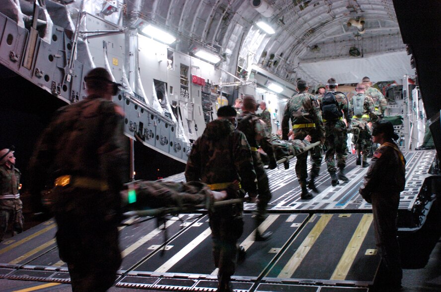 MCCHORD AIR FORCE BASE, Wash. -- Soldiers from nearby Fort Lewis carry mannequins with simulated battle wounds onto a C-17 Globemaster III here June 21 during Rodeo 2005.  Aerial medical evacuation crews were graded on several scenarios during the flight.  (U.S. Air Force photo by Master Sgt. Jack Braden)