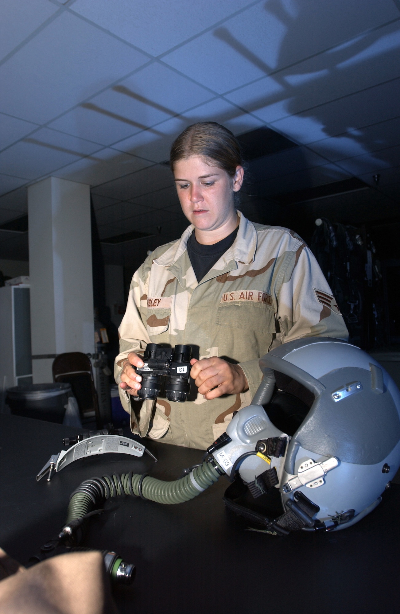 OPERATION ENDURING FREEDOM -- Senior Airman Karen Ainsley inspects night-vision goggles before attaching them to a pilot's helmet.  She is a life support journeyman with the 23rd Expeditionary Bomb Squadron. (U.S. Air Force photo by Staff Sgt. Jocelyn Rich)