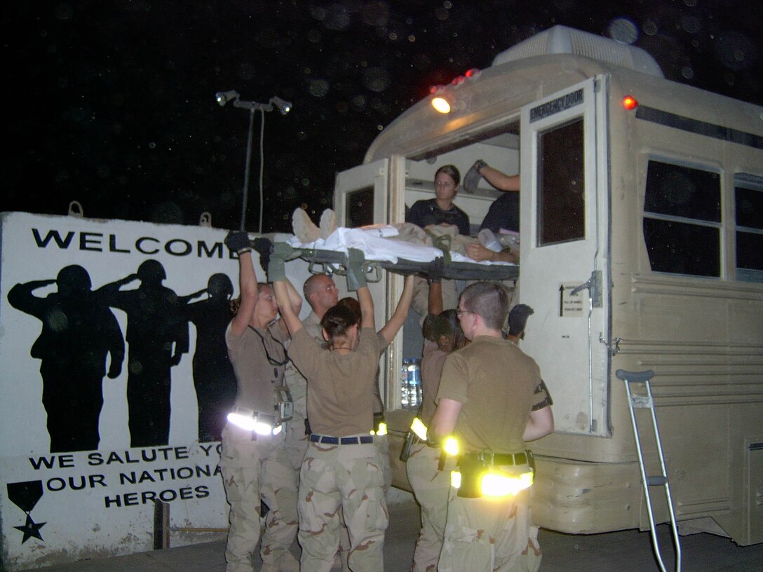 BALAD AIR BASE, Iraq -- Airmen with the casualty staging facility here load patients onto an ambulance bus that take them to an aircraft for a flight to Germany.  Patients in Iraq are usually moved out of theater within 24 to 48 hours of being wounded.  During the Vietnam War, it could take up to six weeks to have a patient ready to travel.  (U.S. Air Force photo by Tech. Sgt. Collen Roundtree)