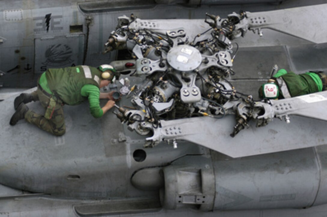 Sailors assigned to Helicopter Anti-Submarine Squadron 14 perform routine corrosion control maintenance on an SH-60F Seahawk helicopter on the flight deck of the aircraft carrier USS Kitty Hawk (CV 63) on June 20, 2005. The Kitty Hawk is operating in the Coral Sea off the coast of Australia's Queensland region as part of Exercise Talisman Saber 2005. Talisman Saber is a combined U.S.-Australia command post and field training exercise, demonstrating the U.S. and Australian commitment to the military alliance and regional security. 