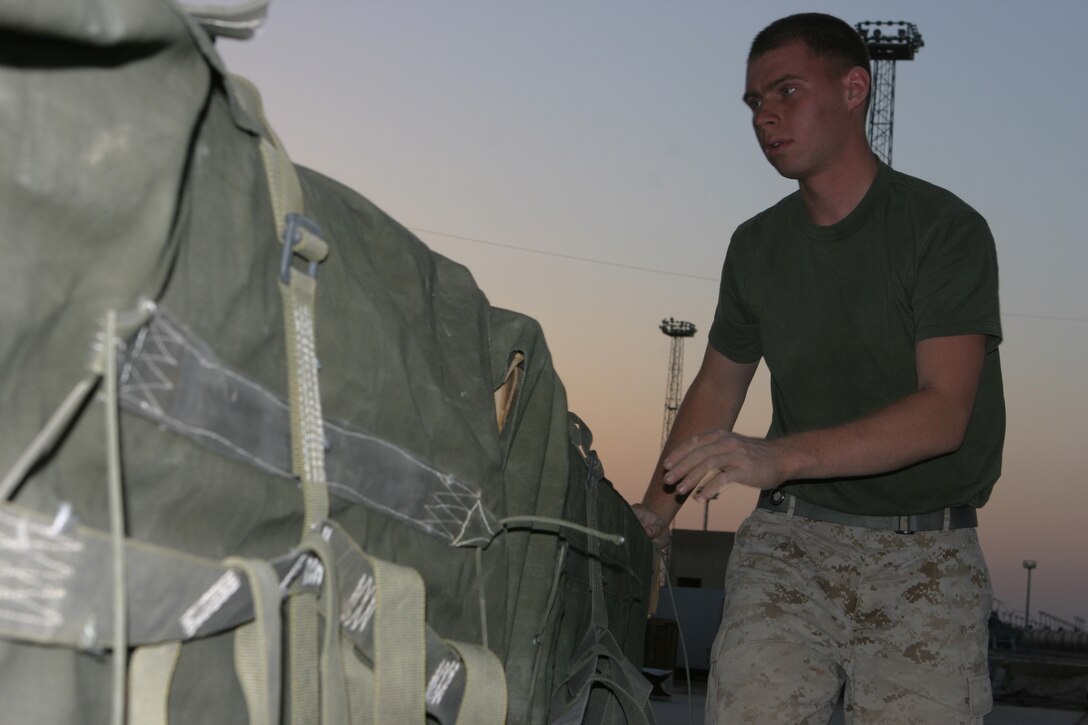 AL ASAD, Iraq (June 26, 2005) - Lance Cpl. Alexander L. Wall, a Grandy, Colo., native, and Marine with Air Delivery Platoon, Transportation Support Company, Combat Logistics Battalion 2, 2d Force Service Support Group (Forward), removes and collects straps and other air delivery gear from a supply bundle after an air delivery was made June 26. Air delivery is used to reduce the number of Marines and vehicles conducting convoy operations to deliver supplies to the various Forward Operating Bases throughout the CLB-2 area of operations.