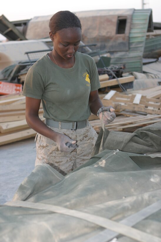 AL ASAD, Iraq (June 26, 2005) - Corporal Jacquelyn M. Gibson, a Miami native, and Marine with Air Delivery Platoon, Transportation Support Company, Combat Logistics Battalion 2, 2d Force Service Support Group (Forward), removes and collects straps and other air delivery gear from a supply bundle after an air delivery was made June 26. Air delivery is used to reduce the number of Marines and vehicles conducting convoy operations to deliver supplies to the various Forward Operating Bases throughout the CLB-2 area of operations.