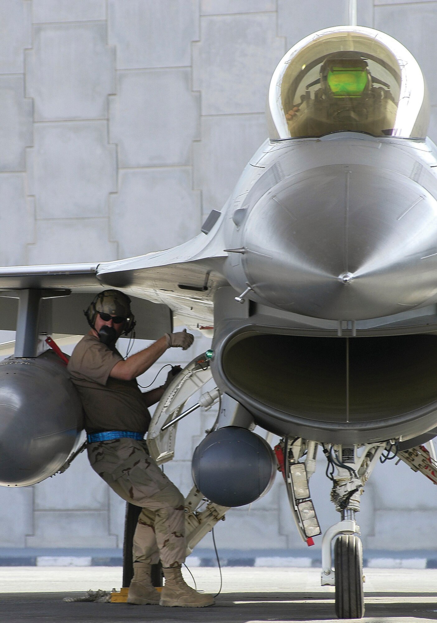 SOUTHWEST ASIA -- Tech. Sgt. Brett Stewart ensures Maj. Tray Siegfried's F-16 Fighting Falcon is ready to head out on a sortie.  Sergeant Stewart is a crew chief assigned to the 379th Expeditionary Aircraft Maintenance Squadron at a forward-deployed location, and Major Siegfried is a pilot assigned to the 125th Expeditionary Fighter Squadron.  (U.S. Air Force photo by Tech. Sgt. Mark Moore)