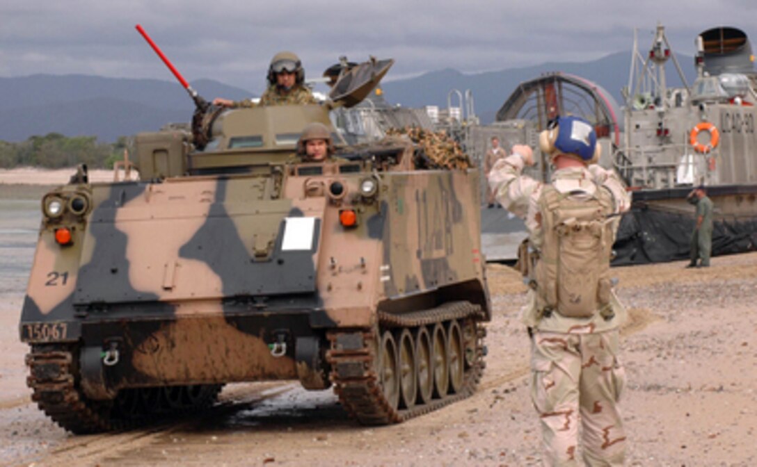 A Navy beachmaster from Assault Craft Unit 5 directs an Australian armored personnel carrier on the beach at Sabina Point in Queensland, Australia, during exercise Talisman Sabre '05 on June 19, 2005. Talisman Saber is a combined U.S.- Australia command post and field training exercise, demonstrating the U.S. and Australian commitment to the military alliance and regional security. 