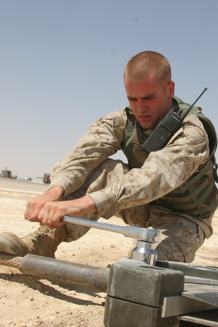 AL ASAD, Iraq ? Lance Cpl. James Connolly, a runway crewman with Marine Wing Support Squadron 271 and Westchester, N.Y., native tightens a bolt on the arresting gear here. Connolly has been with the Work Horses since June 2004 and was excited to join them because of their scheduled deployment here this year.