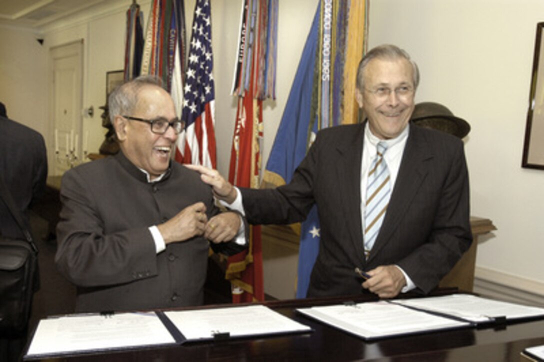 Secretary of Defense Donald H. Rumsfeld (right) and India's Minister of Defense Pranab Mukherjee (left) smile after signing a document in the Pentagon establishing a new framework for the U.S.-India security relationship on June 28, 2005. 
