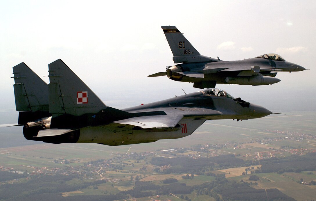 OVER KRZESINY AIR BASE, Poland -- An F-16 Fighting Falcon flies in formation with a MiG-29 here during exercise Sentry White Falcon 2005. The F-16 is assigned to the Illinois Air National Guard's 183d Fighter Wing in Springfield. (U.S. Air Force photo by Tech. Sgt. Shaun Kerr)