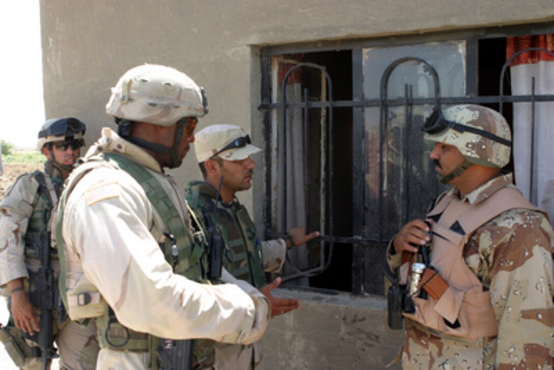 Sgt. 1st Class Randy D. Horton (left) explains through an interpreter to Iraqi Army Sgt. Hassan Sabar Musa (right), that the conduction of the counter-insurgency operation in Tunis, Iraq, will be left to Musa's direction on June 25, 2005. The Coalition forces are in Tunis to help the Iraqis conduct counter-insurgency operations to isolate and neutralized anti-Iraqi forces. Horton is attached to Alpha Troop, 2/11th Armored Calvary Regiment. Musa is attached to the Iraqi Army's 3rd Company, 405th Battalion. 
