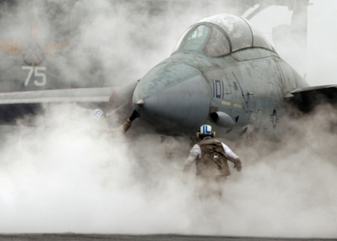 Steam from the catapult envelopes a Navy F-14 Tomcat as the flight crew prepares it for launch from the flight deck of the aircraft carrier USS Harry S. Truman (CVN 75) on Feb. 22, 2005, while underway in the Persian Gulf. The Truman Strike Group and Carrier Air Wing 3 are conducting close air support, intelligence, surveillance, and reconnaissance missions over Iraq. The Tomcat is attached to Fighter Squadron 32 of Naval Air Station Oceana, Va. 