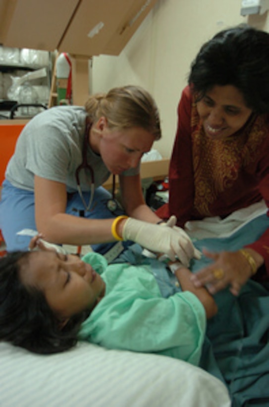 An Indonesian woman comforts her daughter as Registered Nurse Renee Cloutier (center) of Project Hope disconnects an intravenous catheter from her arm aboard the hospital ship USNS Mercy (T-AH 19) on Feb. 23, 2005. Mercy is operating off the coast of Sumatra, Indonesia, providing assistance to international relief organizations and host nation medical teams operating ashore in areas affected by the Dec. 26, 2004, Indian Ocean tsunami. 