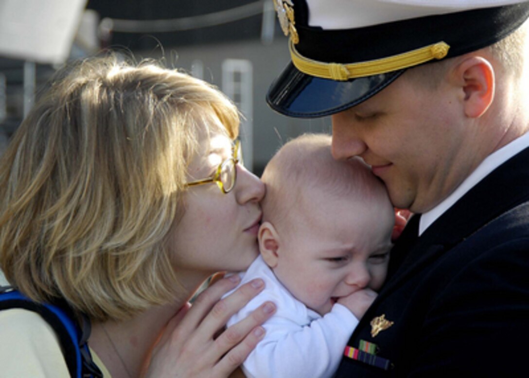 A Navy officer says hello to his child for the first time after returning home to Naval Air Station North Island in San Diego, Calif., from a deployment aboard the USS Abraham Lincoln (CVN 72) on March 1, 2005. The Nimitz-class aircraft carrier Lincoln pulled into San Diego to drop off the sailors and Marines assigned to Carrier Air Wing 2 and then make its transit up the coast to her homeport of Everett, Wash. 