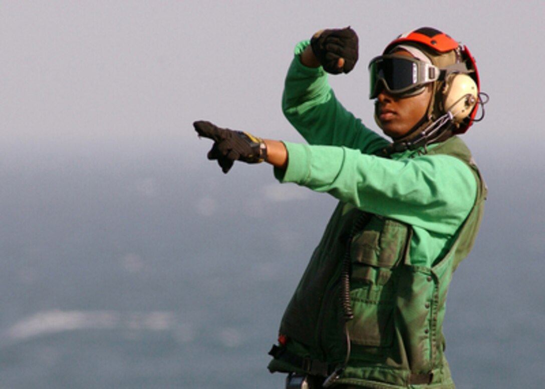 Navy Airman Chara Neal signals the pilot of an SH-60 Seahawk helicopter that there are personnel exiting the aircraft on the flight deck of the aircraft carrier USS Harry S. Truman (CVN 75) as the ship operates in the Persian Gulf on Feb. 1, 2005. The Truman Strike Group and Carrier Air Wing 3 are conducting close air support, intelligence, surveillance, and reconnaissance missions over Iraq. Neal is assigned Helicopter Anti-Submarine Squadron 7 of Naval Air Station North Island, in San Diego, Calif. 