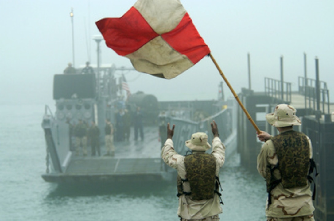 Seamen Jinhan Chen (left) and Michael Kincade direct Landing Craft Utility 1634 to a boat ramp at Kuwait Naval Base on Feb. 26, 2005. The landing craft will on-load Marines assigned to the 31st Marine Expeditionary Unit and transport them to the amphibious dock landing ship USS Harpers Ferry (LSD 49). The Marines of the 31st have been forward deployed to Iraq since July 2004. Chen and Kincade are assigned to Assault Craft Unit 1of Naval Amphibious Base, Coronado, Calif. 