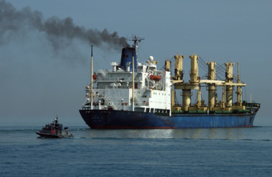 A Navy patrol boat from Inshore Boat Unit 24 escorts a ship out of the Port of Ash Shuaiba, Kuwait, on Feb. 24, 2005. The patrol boat is assigned to Naval Coastal Warfare Squadron 25. 