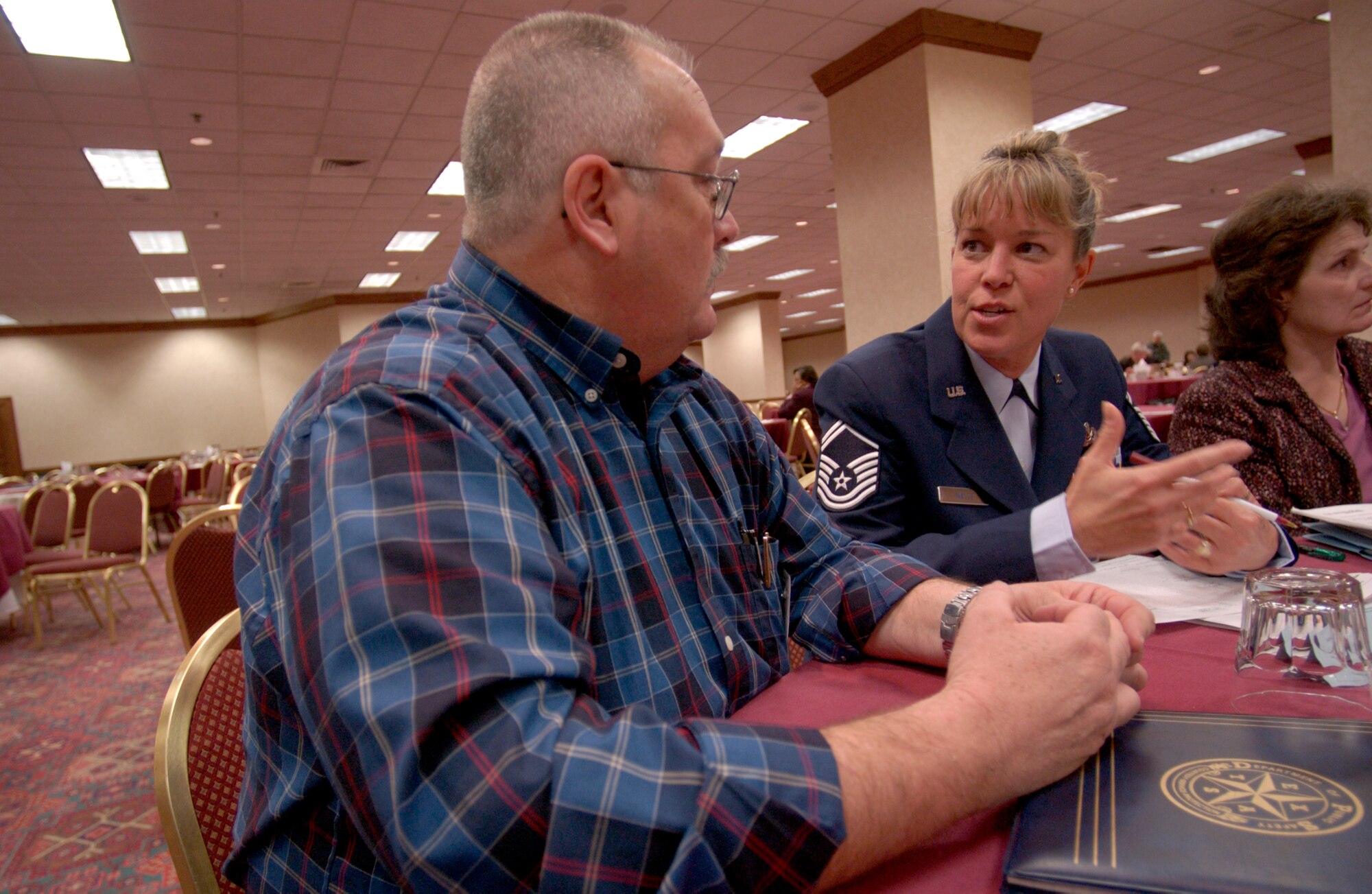 SAN ANTONIO -- Senior Master Sgt. Cheryl Wells talks with David Lewis during the Department of Defense family member update here Feb. 26.  Mr. Lewis' father, Col. James Lewis, was a B-57 Canberra pilot during the Vietnam War.  He disappeared during a mission on April 7, 1965.  Sergeant Wells is assigned to the Air Force Personnel Center missing persons branch here.  (U.S. Air Force photo by Master Sgt. Lance Cheung)